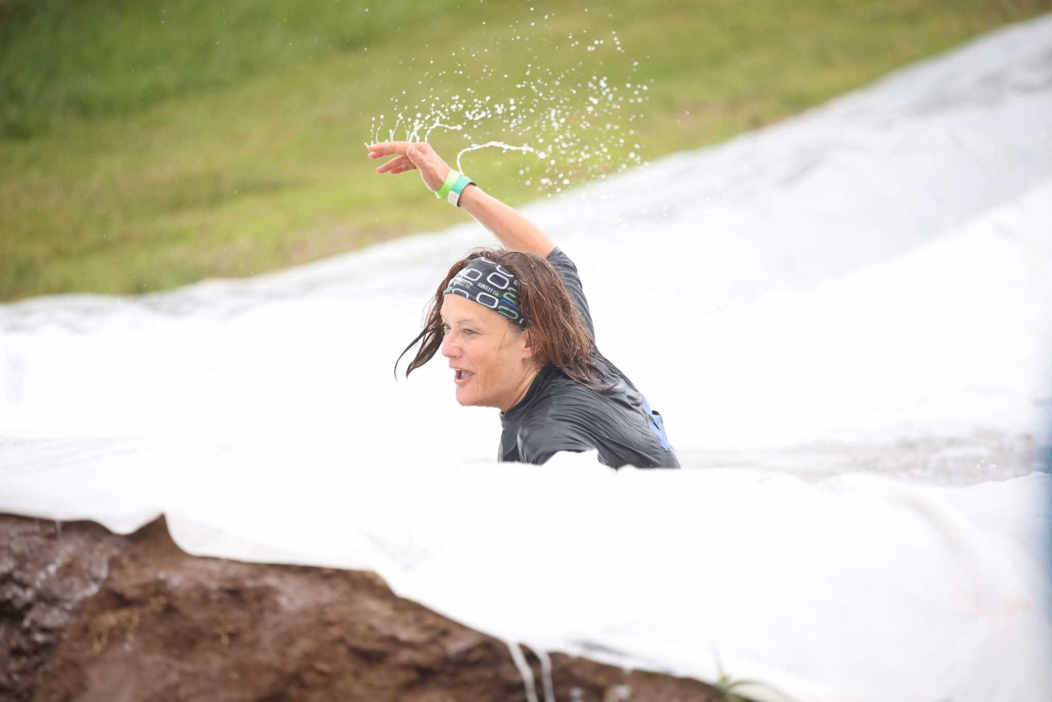 A runner slides down the water slide on the Gaylord Gauntlet course