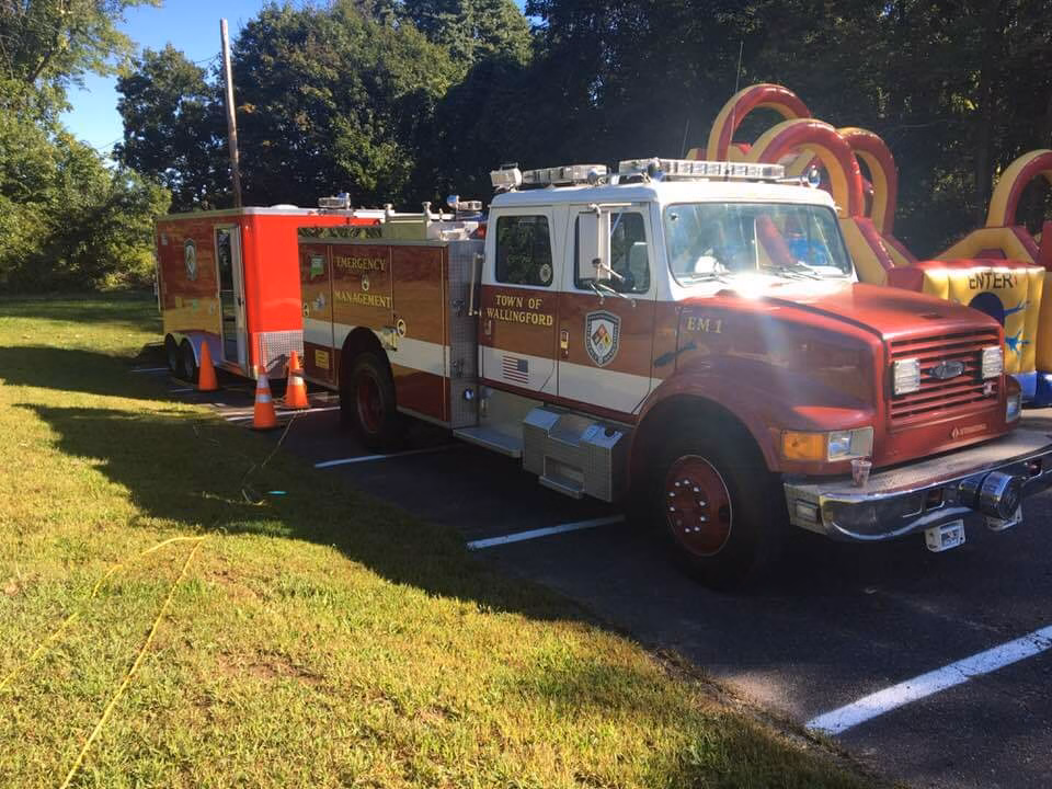A Wallingford fire truck parked at a community event beside a bounce house