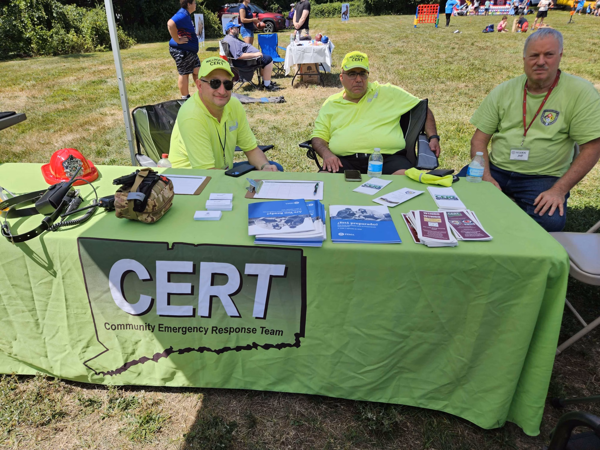 CERT volunteers at an outreach table with brochures and kits